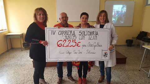 Miembros de la Asociación Galbán, Marisa, profesora del centro y coordinadora de la carrera y Covadonga Fernández, directora del CP San José, con el cheque simbólico del dinero recaudado en la carrera.